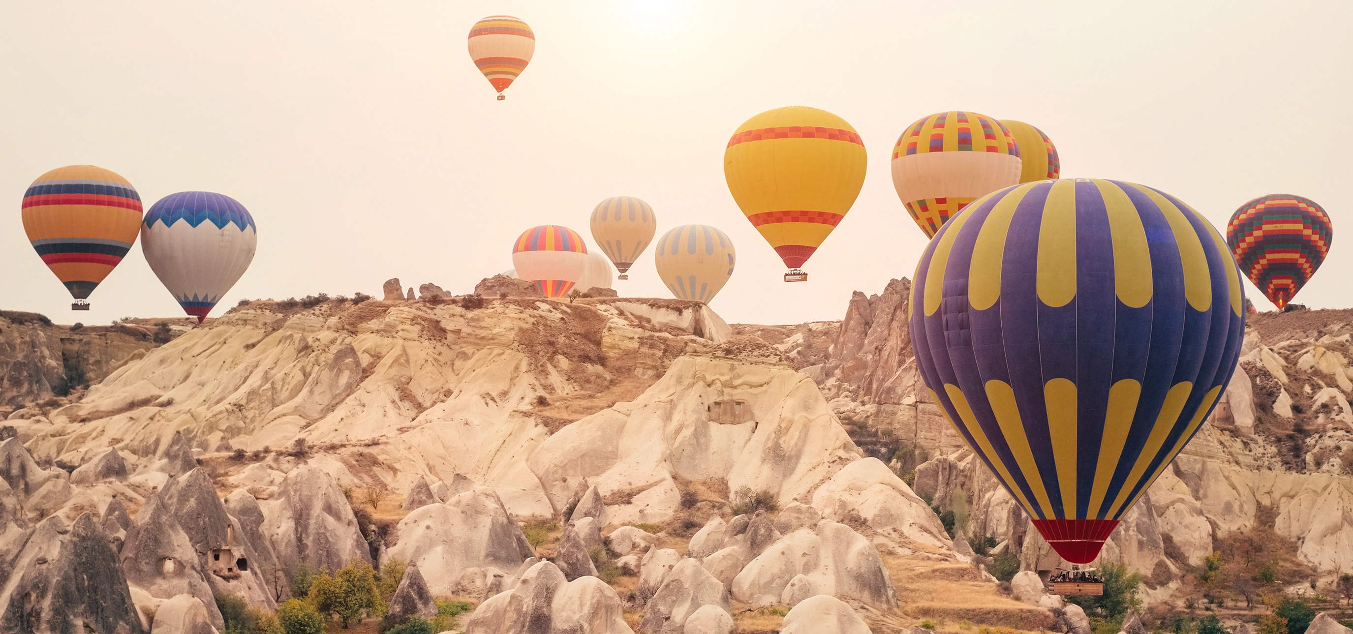 Hot air balloons over Cappadocia fairy chimneys at sunrise