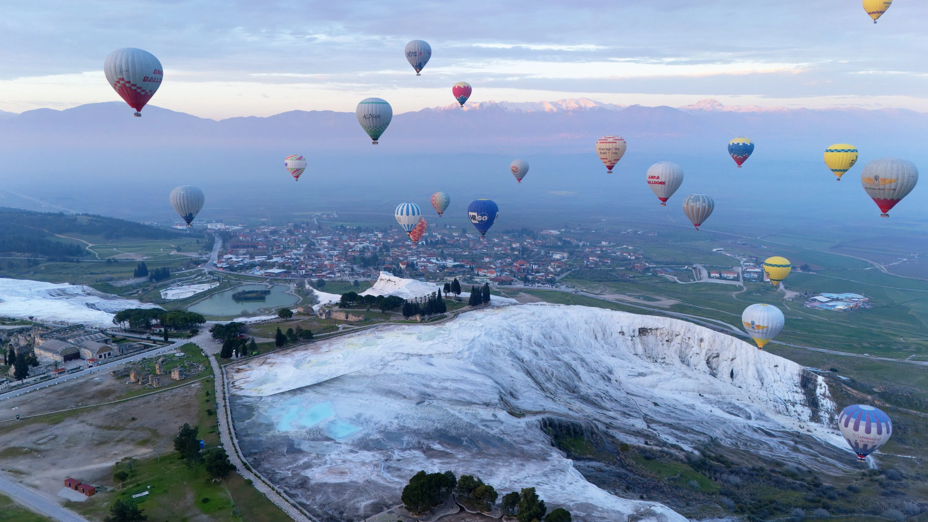 Hot air balloons flying over Pamukkale at sunrise